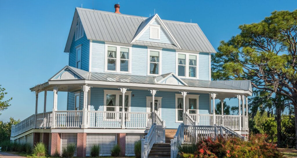 metal beach house roof with porch surrounded by trees and shrubs